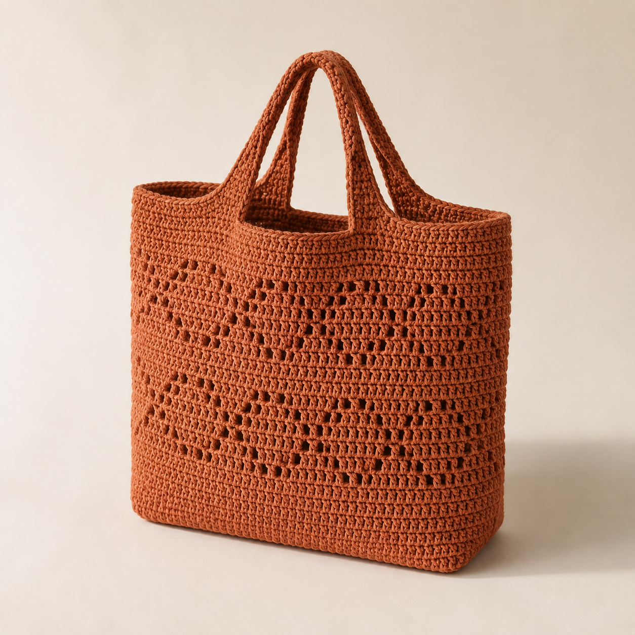 Terracotta hand-crocheted market tote on a cream background